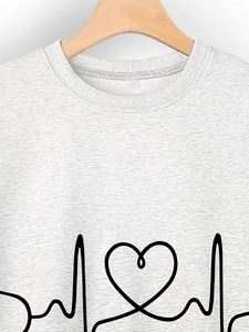 Close-up of minimalist stethoscope heart and ECG line print on grey crewneck sweatshirt