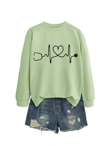 Detail of light green sweatshirt with heartbeat stethoscope print and ripped denim shorts