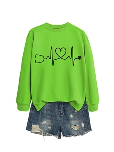 Flat lay of neon green sweatshirt with stethoscope heart print and ripped denim shorts
