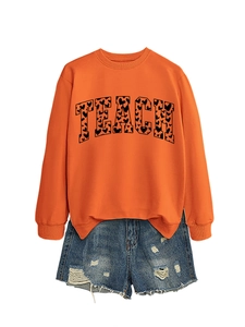 Detail of orange sweatshirt with TEACH heart print and distressed blue denim shorts
