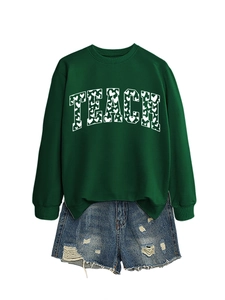Detail of TEACH college-style print with small heart patterns on green sweatshirt