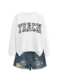 Detail of Teach letter print with black heart pattern on white crewneck sweatshirt