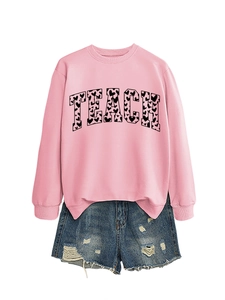 Flat lay of pink sweatshirt with TEACH heart print paired with denim shorts