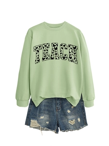 Detail of TEACH letter print with heart patterns on light green long sleeve sweatshirt