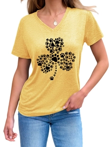 Détail du t-shirt jaune gingembre à col en V avec un motif créatif de trèfle et de pattes