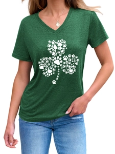Détail d'un t-shirt vert à col en V avec un motif trèfle en empreintes de pattes blanches