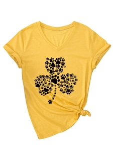 Détail du t-shirt jaune gingembre à col en V avec motif de trèfle et pattes de chien