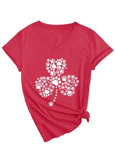Détail du t-shirt rouge col en V avec motif trèfle en pattes et ourlet noué à la mode
