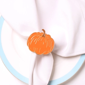 Detailed close-up of an orange pumpkin napkin ring on a white porcelain plate