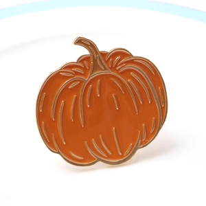 Rond de serviette citrouille d'Halloween en émail orange et métal doré sur plateau
