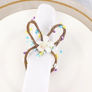 Handmade woven rabbit ear napkin ring with colorful berries and white flower on a plate
