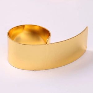 Macro shot of gold spiral napkin ring with polished metallic finish for luxury dining