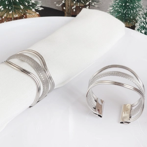 Detail of silver metal napkin ring with woven mesh texture on a white holiday dining table
