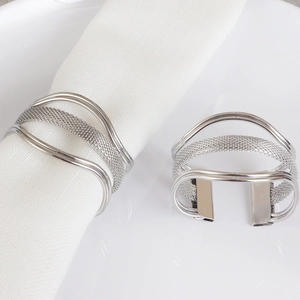 Close-up of silver metal woven napkin rings showing polished texture on white linen