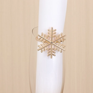 Close-up of a golden snowflake napkin ring with metallic luster on white fabric