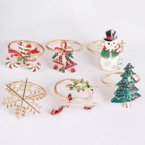 Set of 6 Christmas napkin rings featuring enamel snowman, reindeer and holiday tree motifs