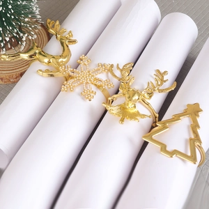 Set of four gold metal Christmas napkin rings with reindeer and snowflake details