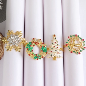 Detail of four festive Christmas napkin rings with gold plating and enamel inlay