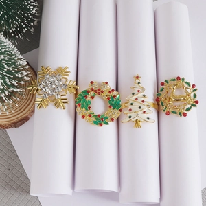 Macro view of gold Christmas napkin rings with enamel holiday designs and rhinestones