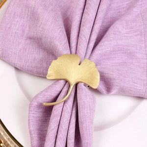 Detail of golden ginkgo leaf napkin ring showing delicate metal texture and veins