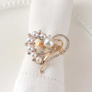 Elegant gold heart napkin ring with white pearls and rhinestones on white napkin