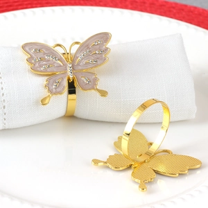 Elegant gold butterfly napkin ring with purple enamel and diamonds on white plate