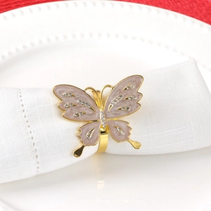 Luxurious gold butterfly napkin ring with pink enamel and crystals on white cloth
