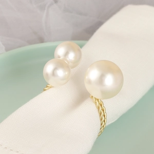 Twisted gold metal napkin ring with three white pearls for elegant holiday table settings