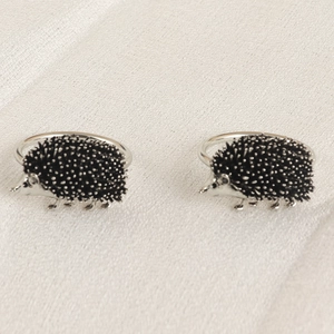 Détails de ronds de serviette hérisson en métal argenté avec textures noires fines
