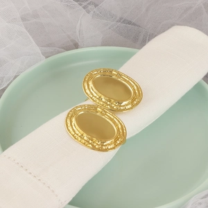 Set di 2 portatovaglioli ovali dorati con finitura martellata su lino bianco