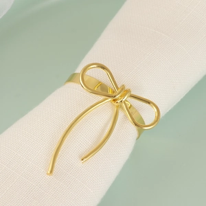 Golden bow napkin ring with wire design on a white linen napkin for table decor