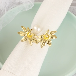 Golden floral napkin ring with white pearl on white cloth napkin for table decor