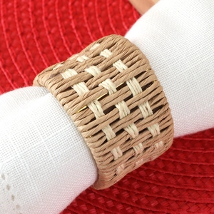 Handwoven rustic linen napkin ring with two-tone texture on a white cloth napkin