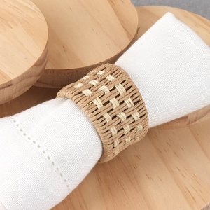Handmade woven linen napkin ring with dual-tone texture on a white cloth for table decor
