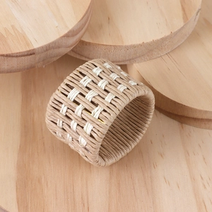 Macro shot of checkered woven linen napkin ring on natural round wooden blocks