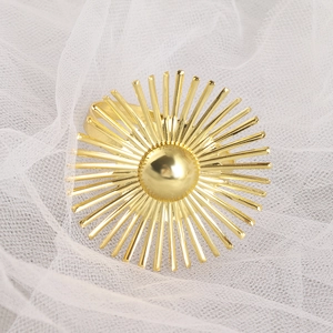 Elegant gold sunburst metal napkin ring on white mesh background for hotel wedding decor