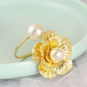Rond de serviette fleur dorée avec perles sur dentelle blanche et assiette en céramique