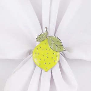 Yellow lemon napkin ring with green leaves on white napkin for elegant table setting