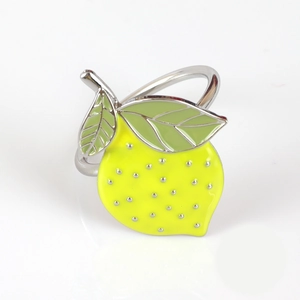Macro shot of yellow lemon napkin ring with silver finish and green enamel leaves
