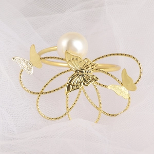 Elegante servilletero de mariposa dorada con perla blanca y base de metal tejido