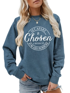 Close-up of ribbed crewneck and white circular religious print on blue casual sweatshirt