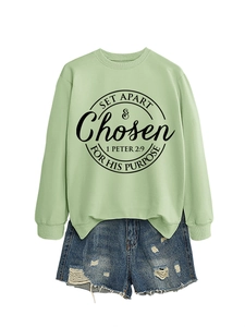 Detail of light green sweatshirt with religious print and ripped denim shorts set