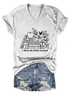 Flat lay of a white V-neck t-shirt with book theme graphics and ripped denim shorts