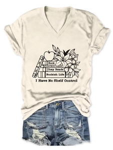 Close-up of cream V-neck T-shirt with book and lily print and rolled cuffs