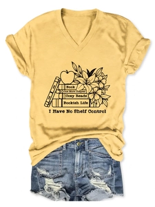 Detailed flat lay of a yellow V-neck T-shirt with 'Cozy Reads' graphic and denim shorts