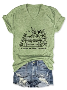 Detailed flat lay of a grass green V-neck T-shirt with book graphic and distressed denim shorts