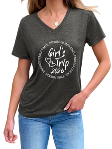 Detail view of the V-neck and white Girl's Trip 2026 circular print on dark gray shirt