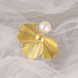 Rond de serviette fleur dorée avec perle centrale sur fond de maille blanche chic