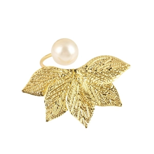 Elegant gold leaf napkin ring with white pearl detail for luxury hotel table setting