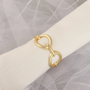 Detailansicht eines mattgoldenen geometrischen Serviettenrings mit Kettendesign